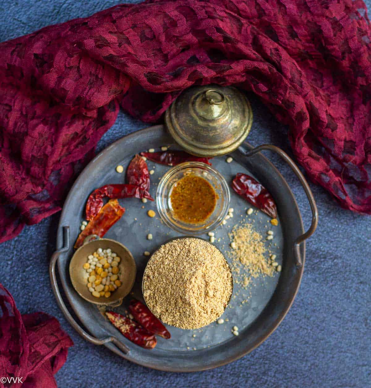 overhead shot of idli podi placed on a tray with some podi mixed with oil
