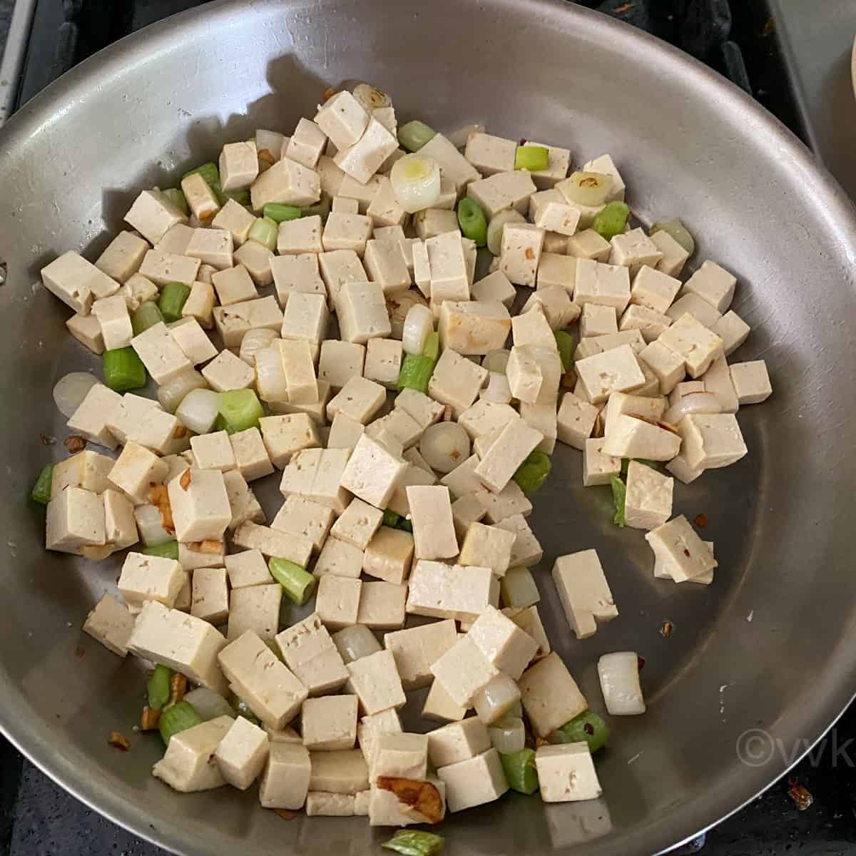 adding tofu and cooking until it slightly browns