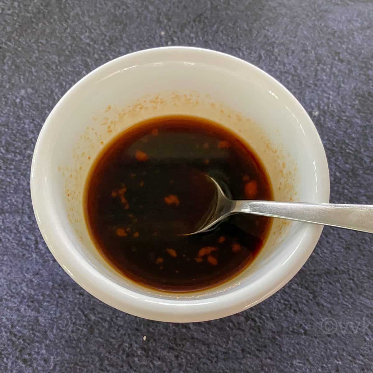 the sauce required for wrap filling in a white bowl with spoon