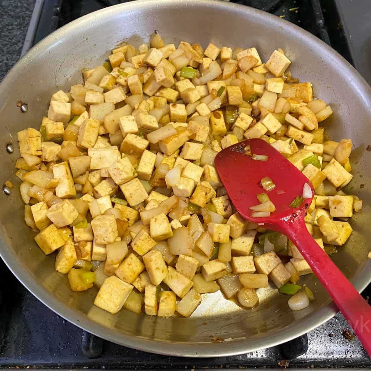 adding the sauce to the tofu mix