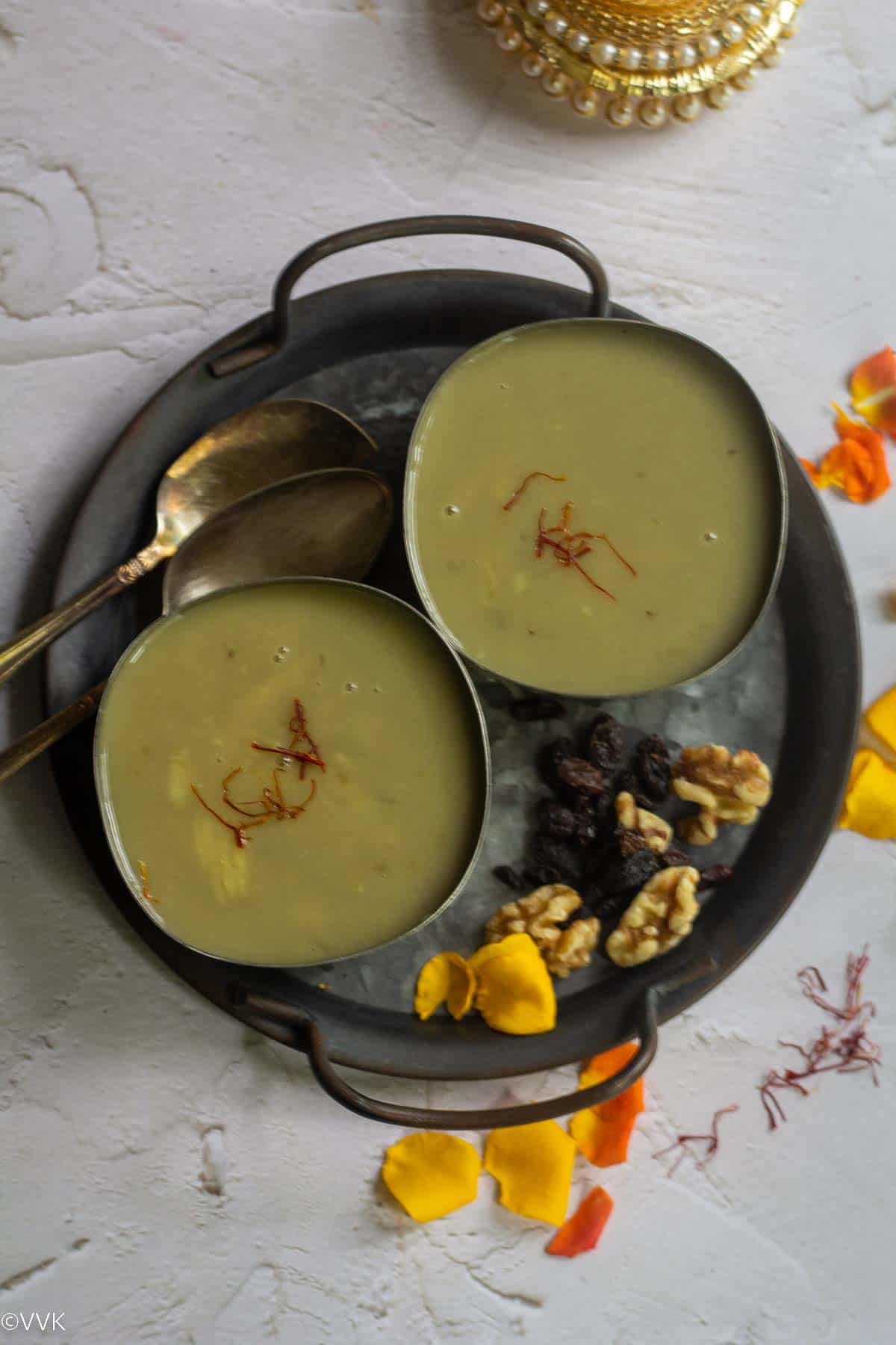 sakkaravalli kizhangu payasam served in two bowls placed on iron tray with nuts on the side