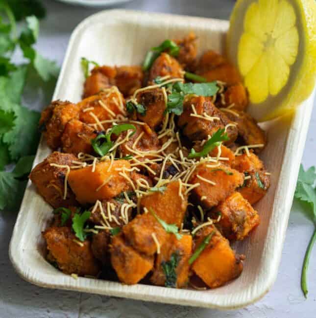 square image of sweet potato chaat served in leaf plate