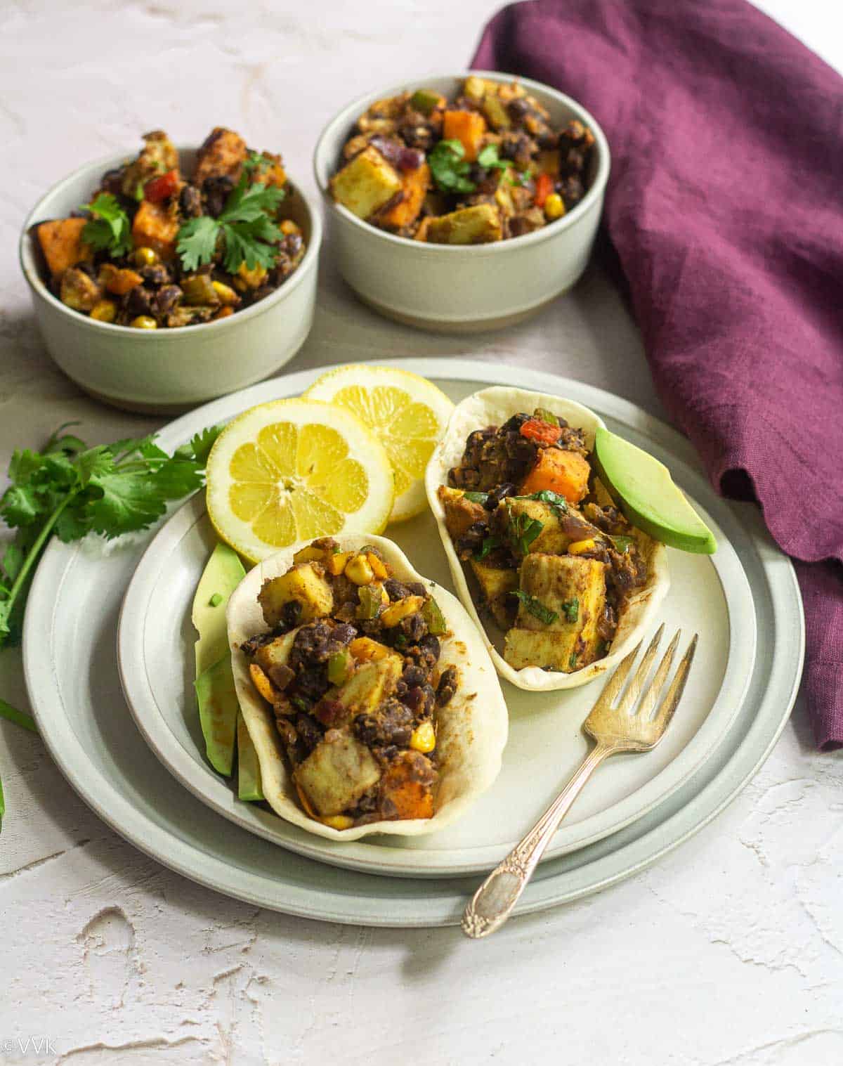 sweet potato tex-mex with beans served in two bowls and tacos