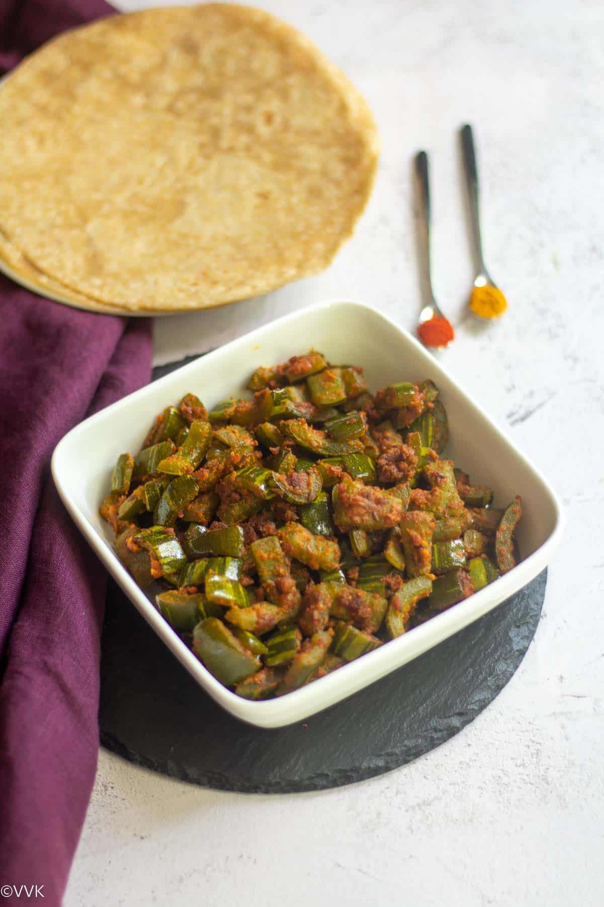 snake gourd curry served with roti with some spices on the side