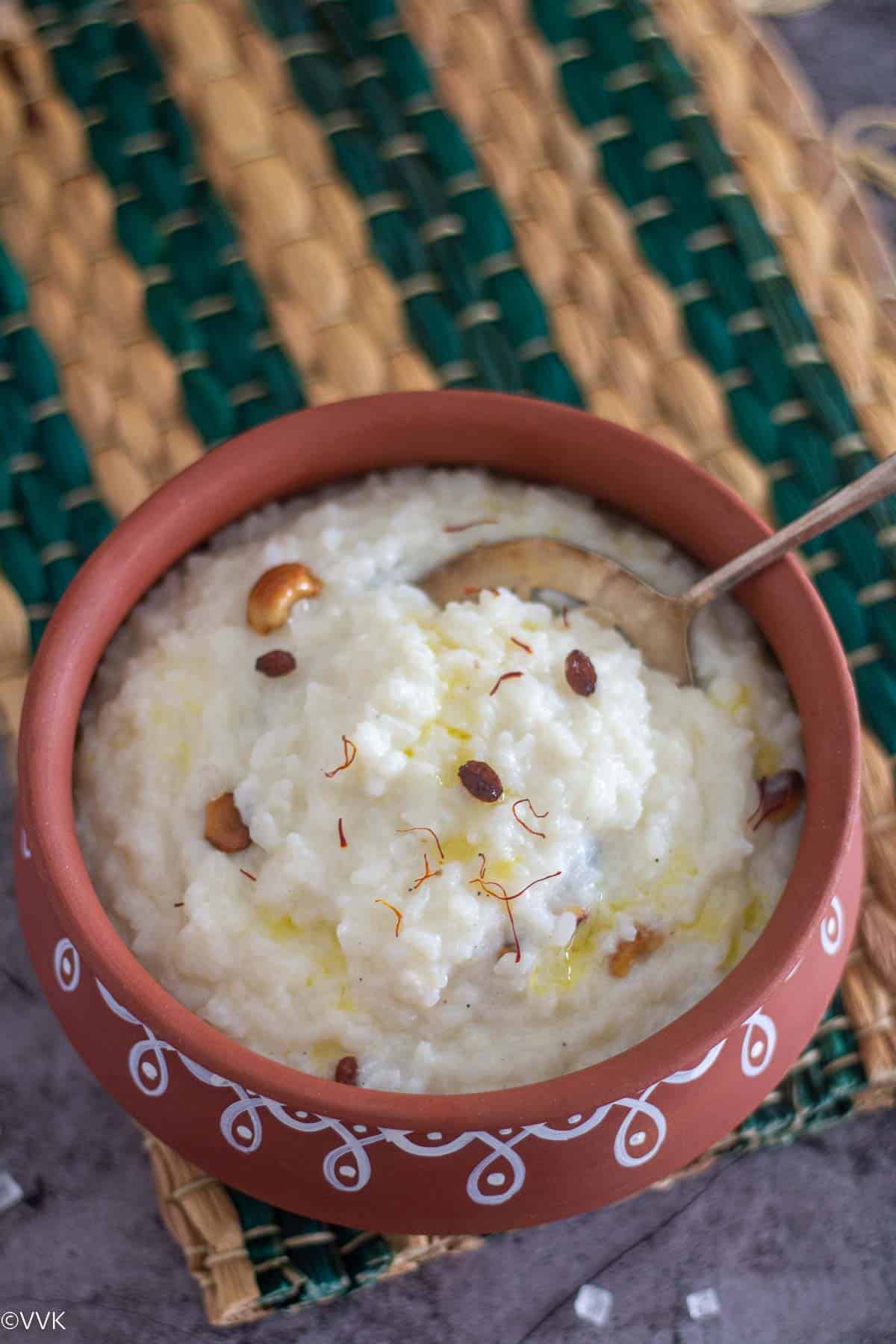 instant pot kalkandu sadam served in clay pot with spoon inside