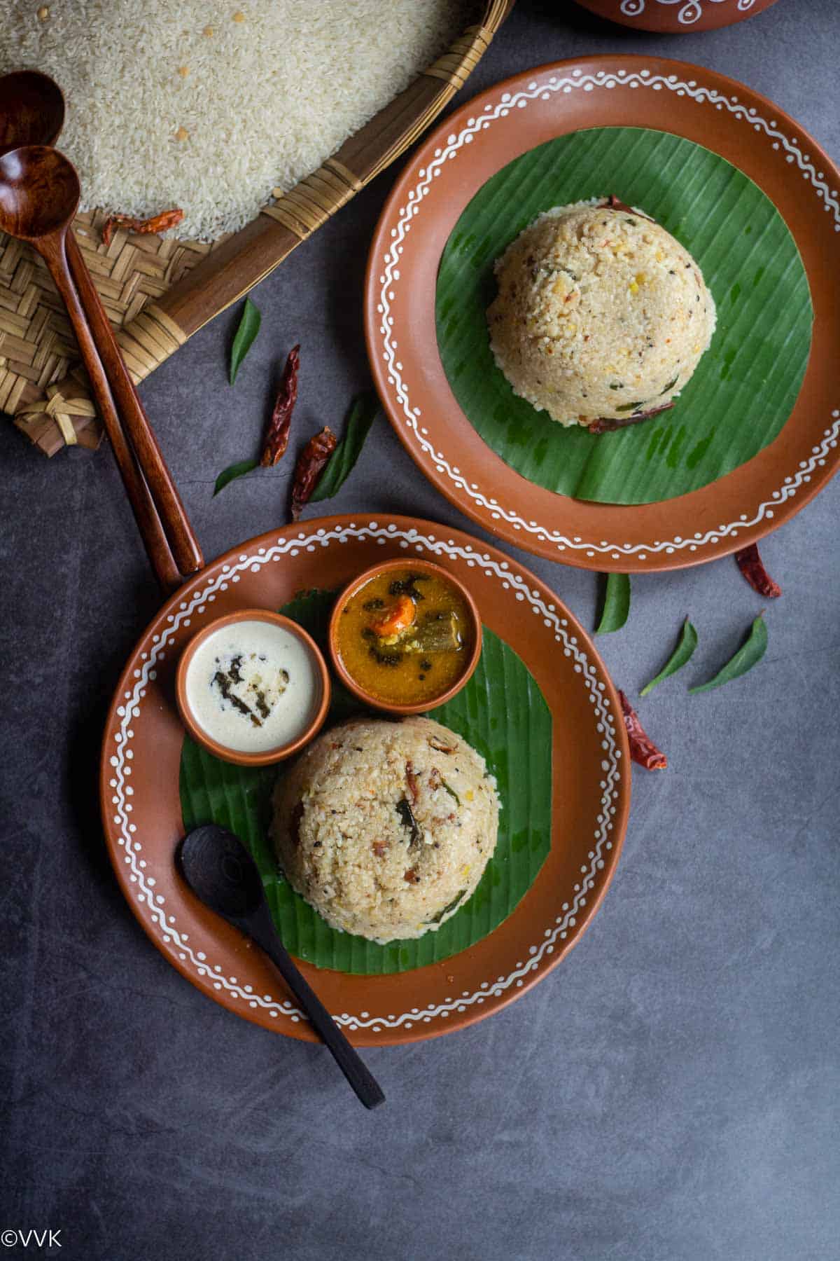 overhead shot arisi upma served in two plates with chutney and sambar