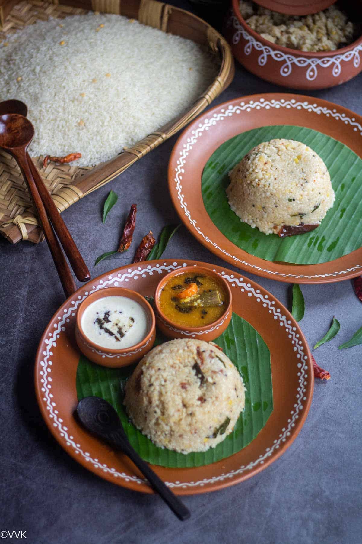 arisi upma served in two plates placed on banana leaf with rice on a winnow