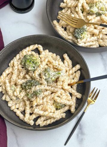 cream cheese pasta served in two bowls with fork inside