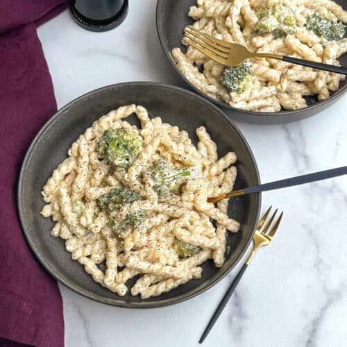 cream cheese pasta served in two bowls with fork inside