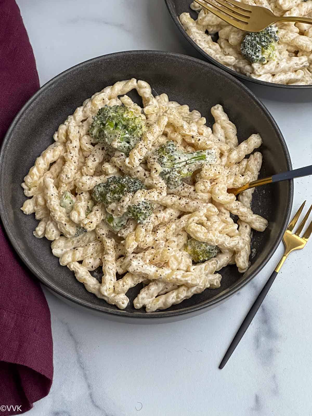 close up shot of creamy pasta with broccoli served in bowl