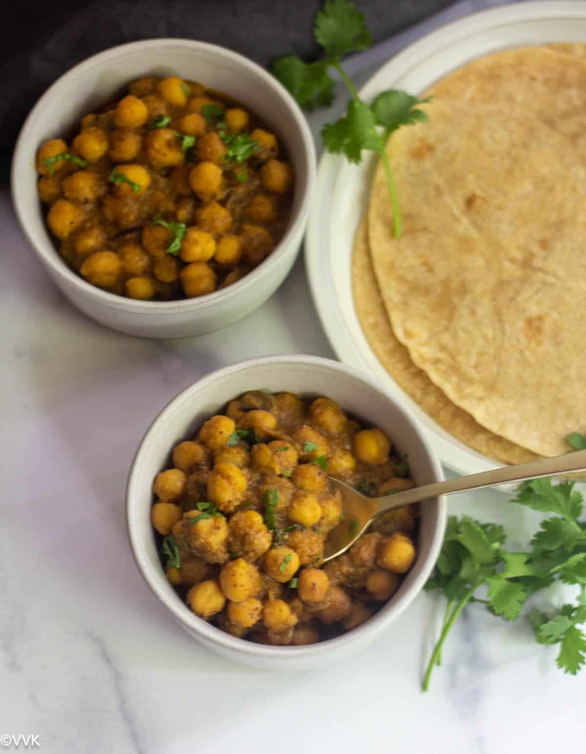 chickpeas kurma south indian style served in two bowls with cilantro on the side