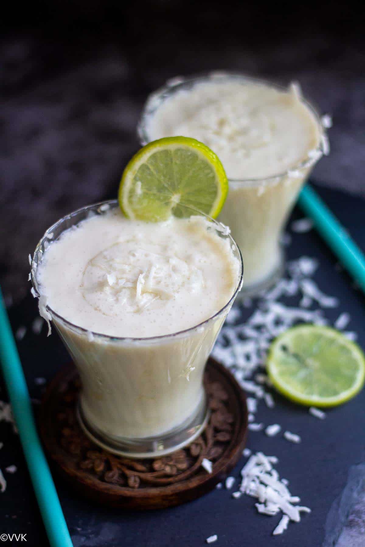 coconut milk limeade served in two glasses with lime wedge on top