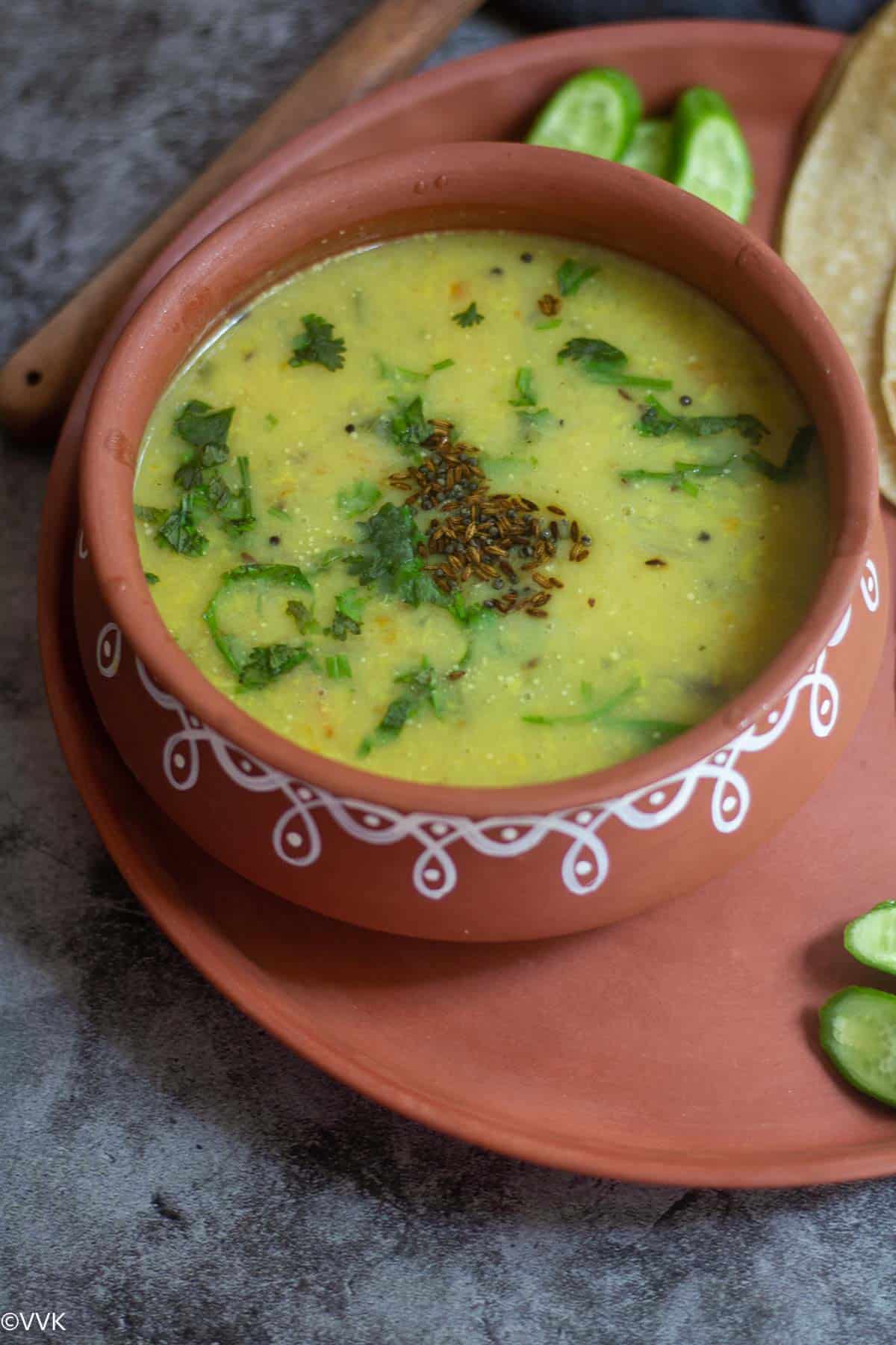 moong dal tadka served in clay pot with rotis on the side