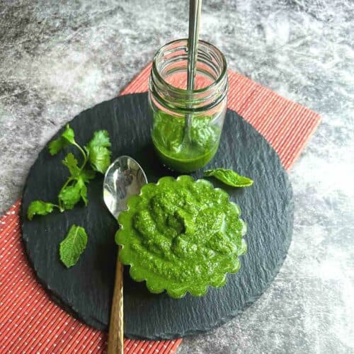 square image of green chutney served in bowl and bottle