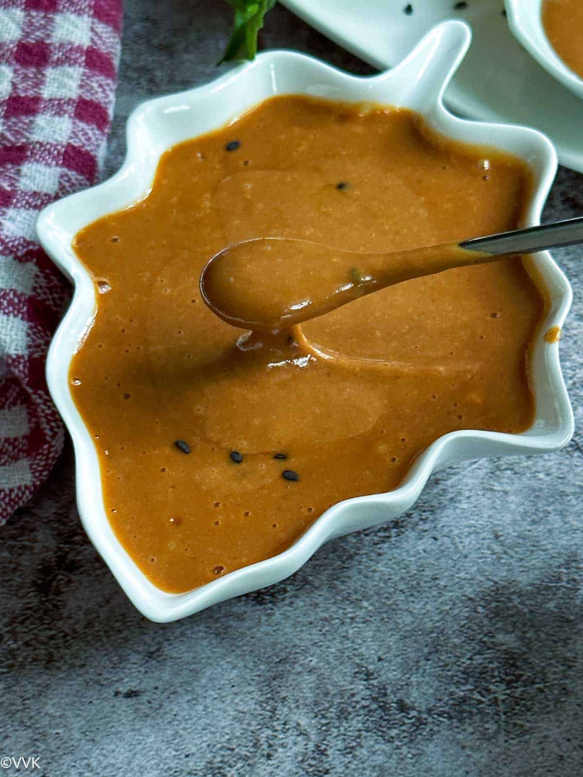 close up shot of thai peanut sauce with spoon full of sauce