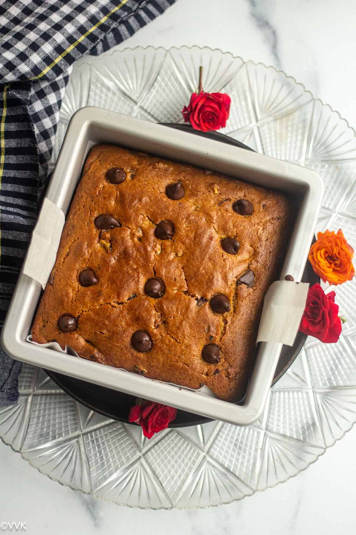 chocolate chip cake right out of oven in the pan with roses on the side