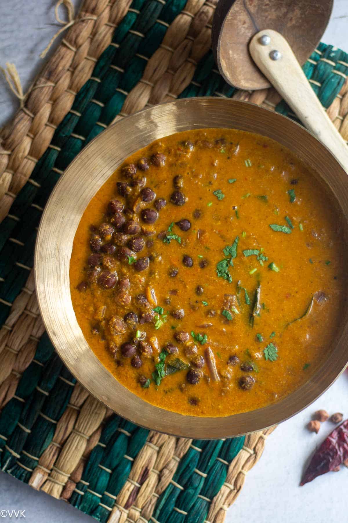 overhead shot of chickpea curry served in brassware