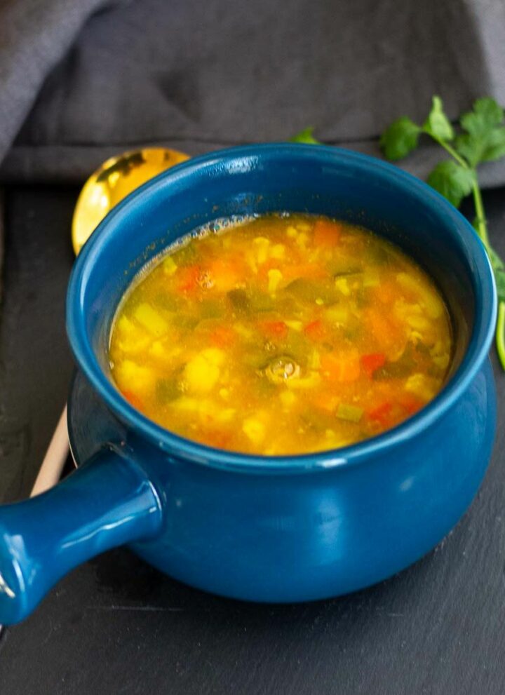 square image of barley soup served in blue soup crock pot