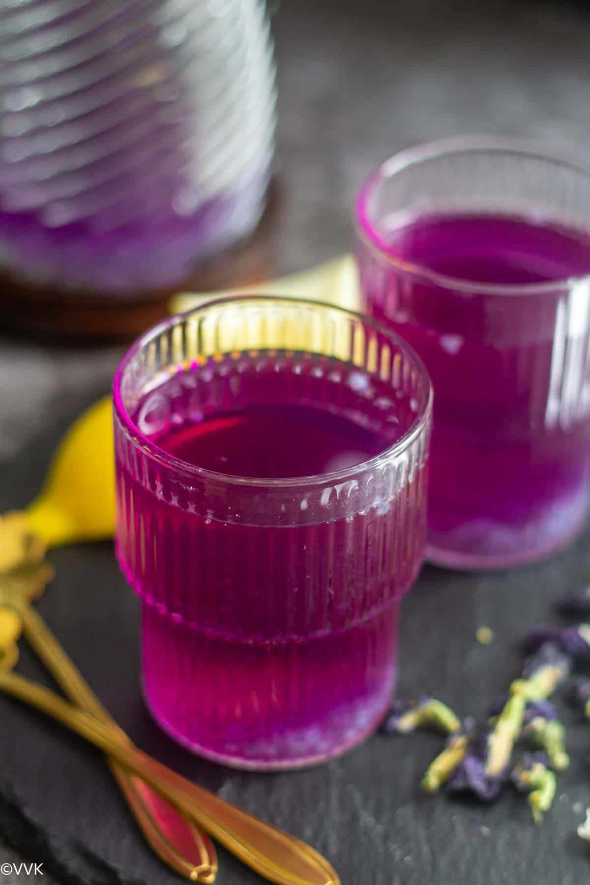 two glasses full of purple lemonade 