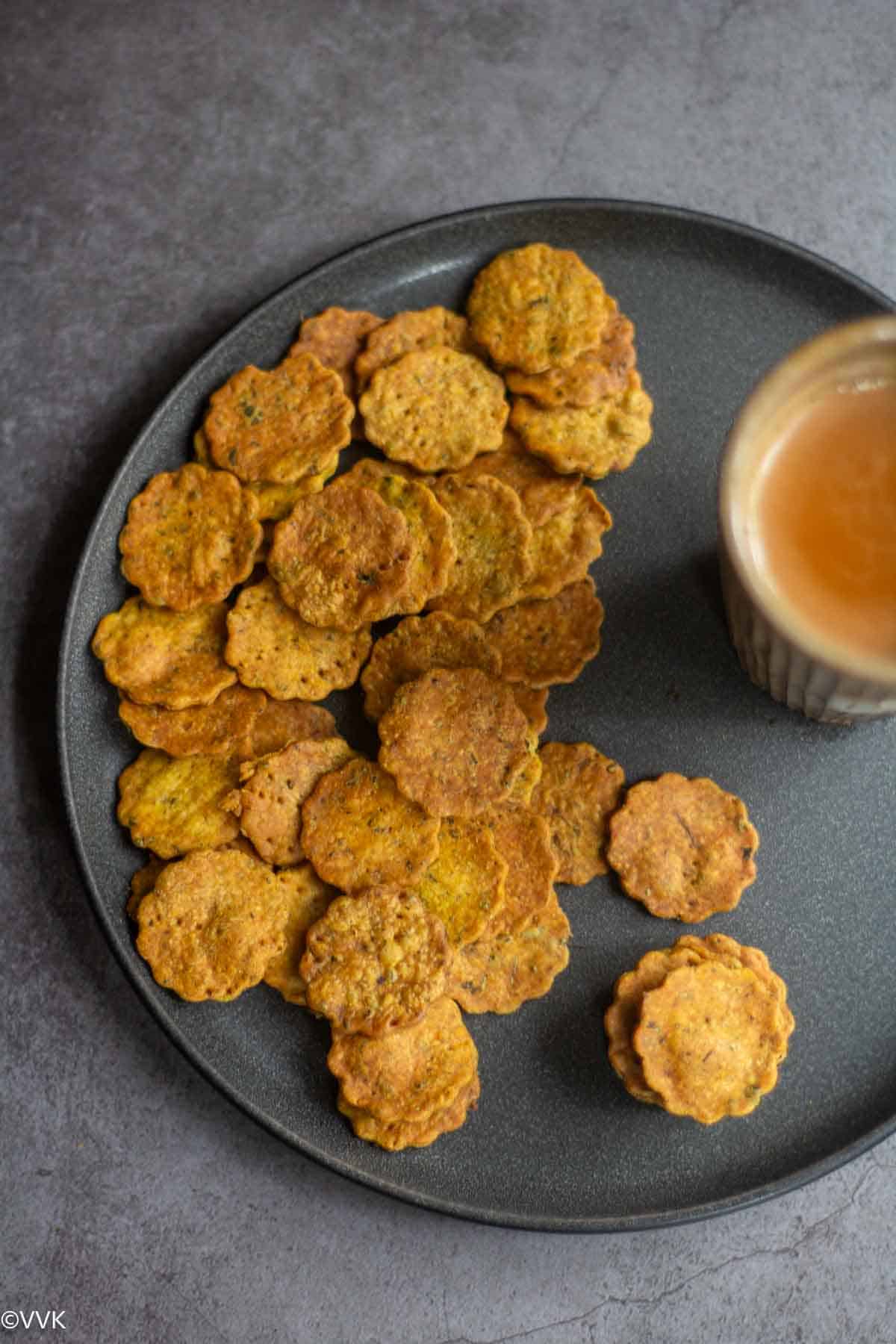 overhead shot of baked methi mathri served with tea