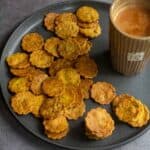 square image of baked methi mathri served with tea