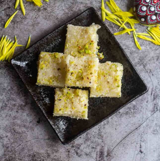 Overhead shot of coconut burfi placed in black plate