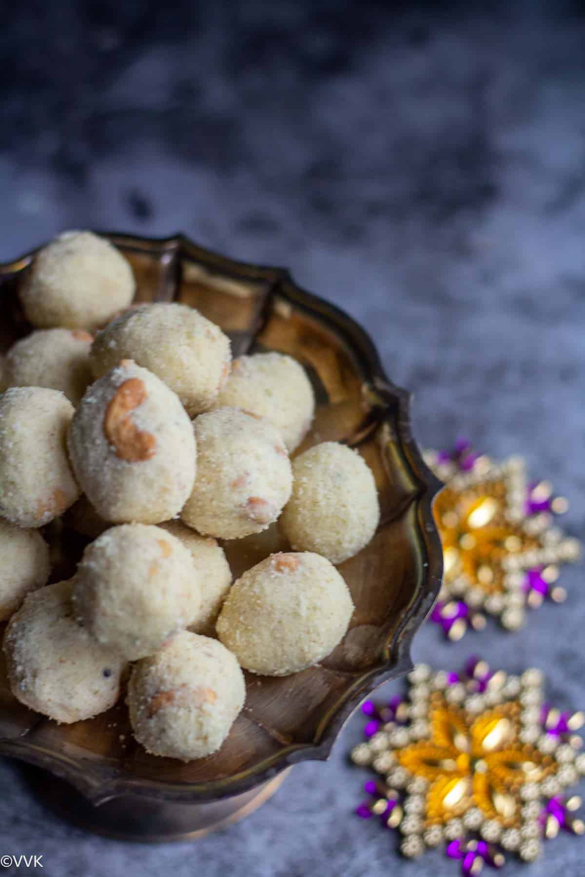 slanting shot of sooji laddu with two rangoli designs on the side
