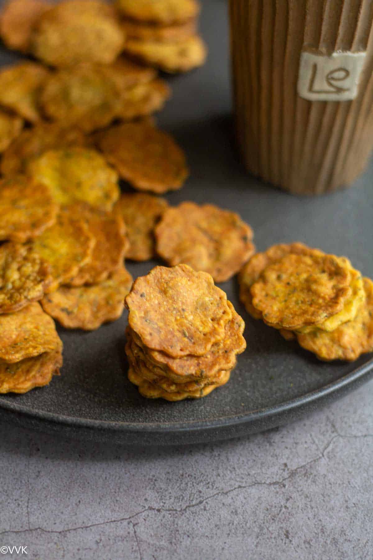 close up shot of stacked methi mathri placed on a plate