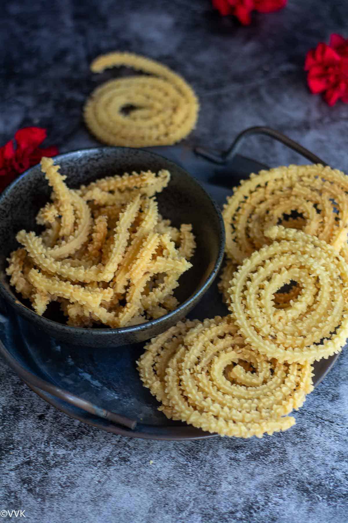 stacked butter murukku and it's pieces in a bowl