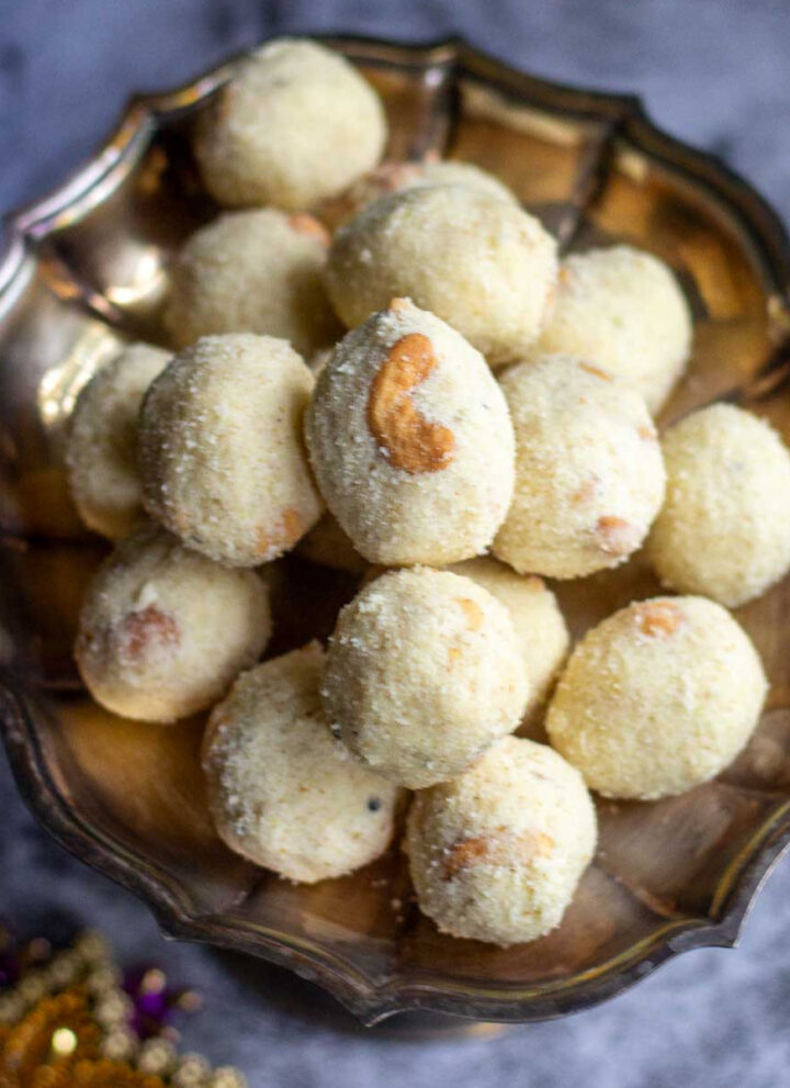 square image of rava laddu stacked in a silver plate
