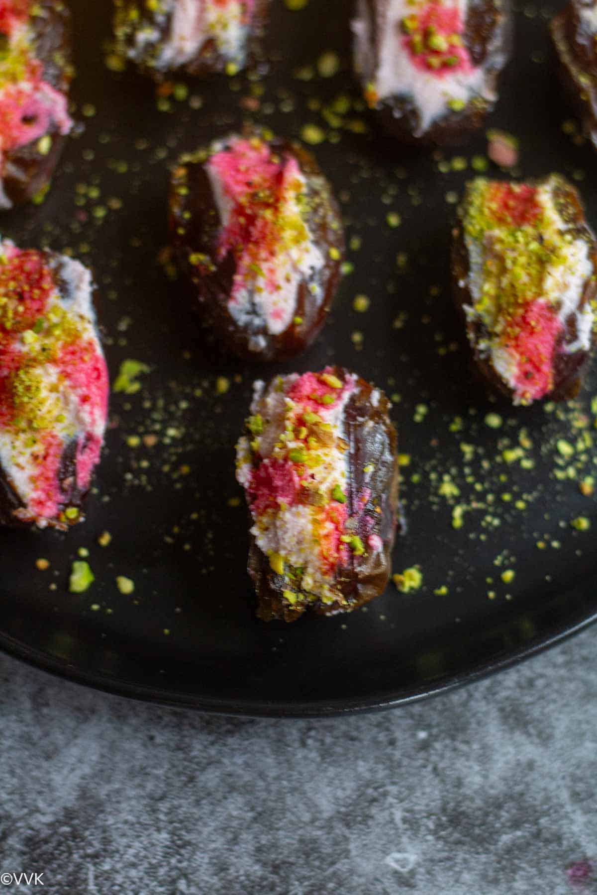 close up shot dates stuffed with ricotta served in black plate