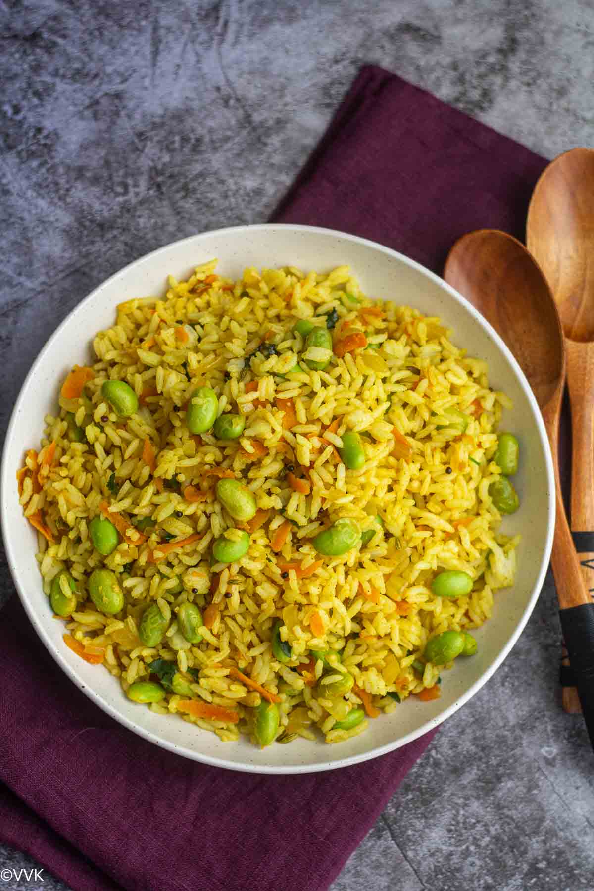 protein edamame rice served in white plate placed on purple napkin