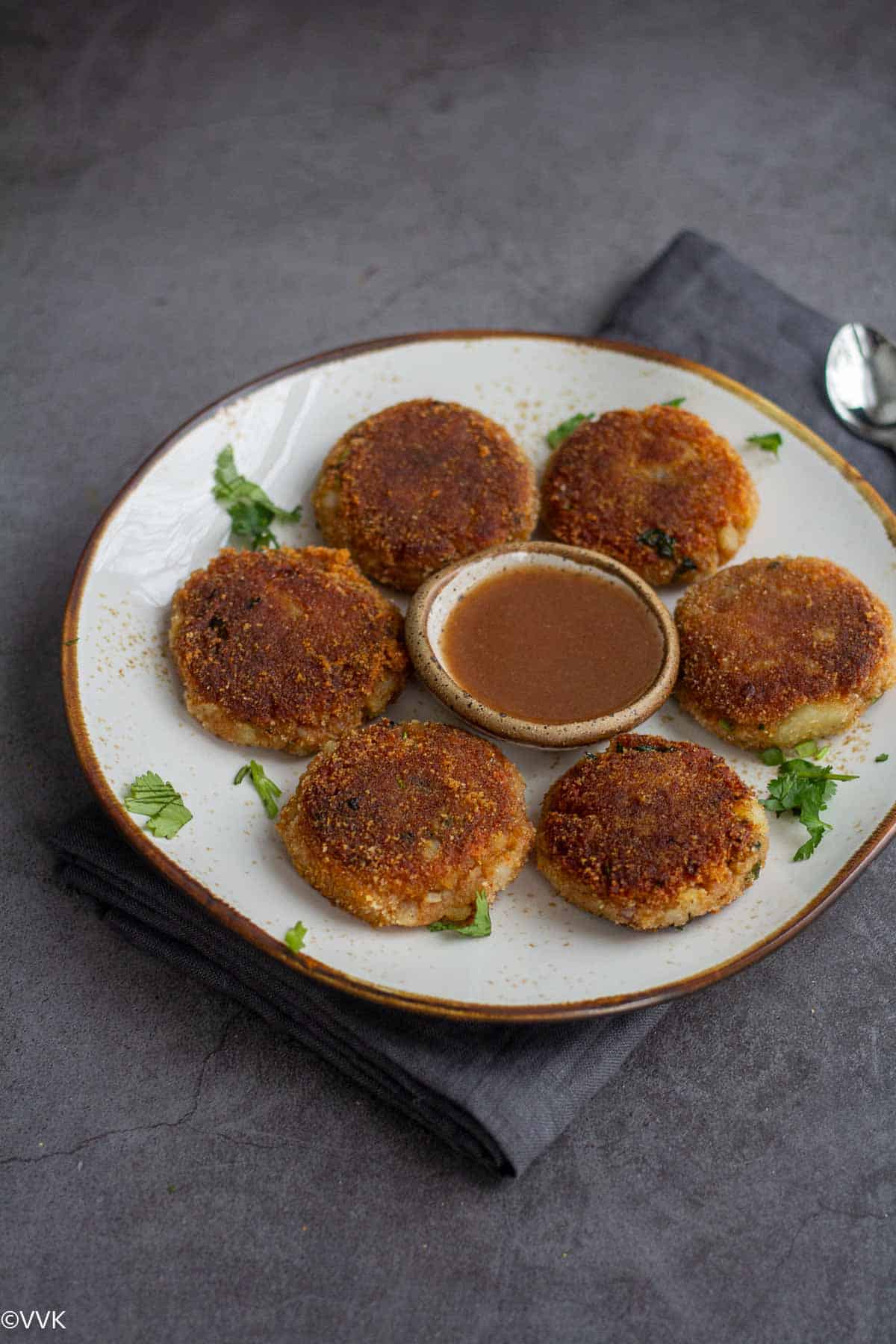 long shot of potato cutlets served with sweet chutney