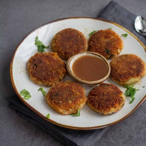 square image of aloo tikki served with sweet chutney