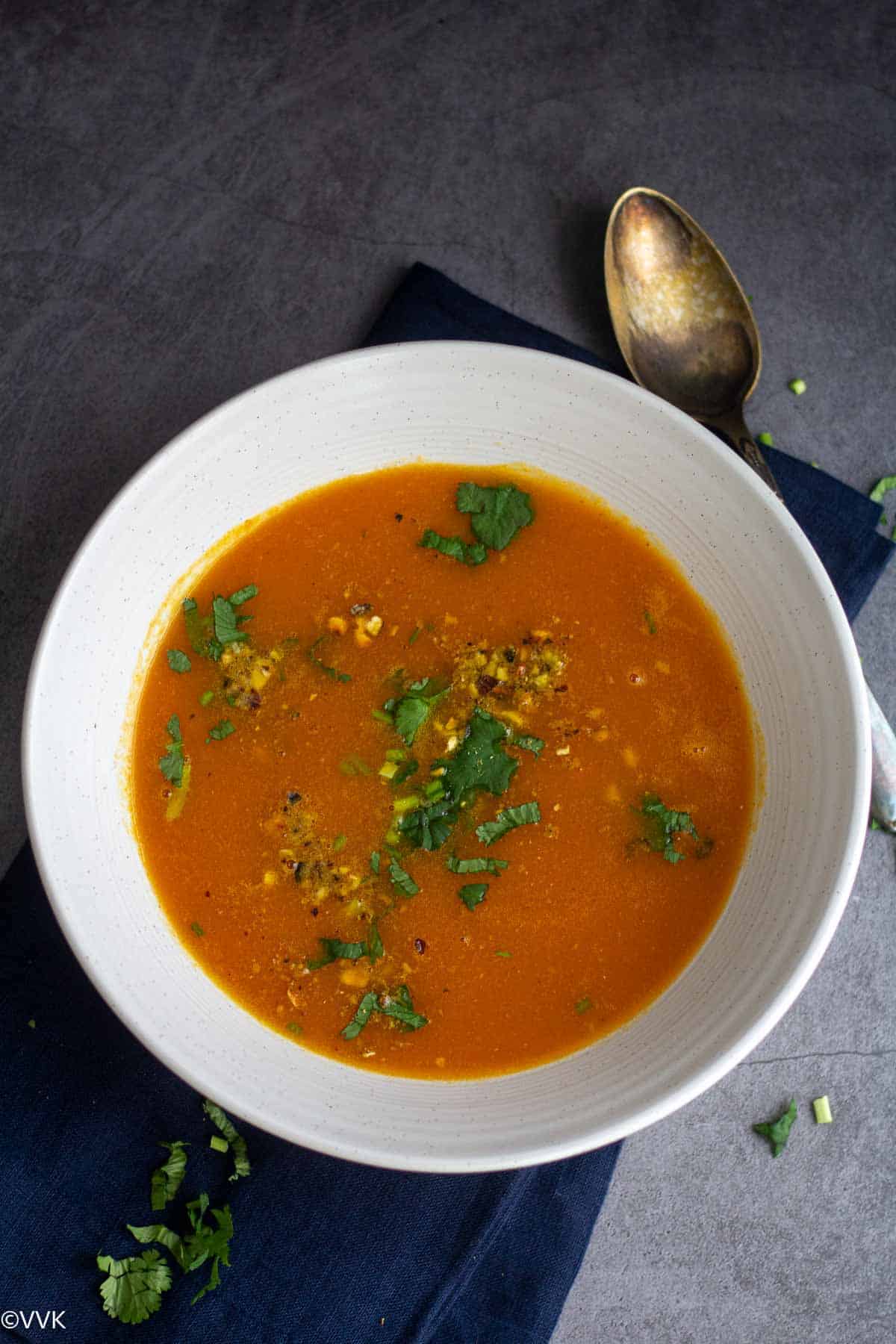 overhead shot of carrot ginger soup with spoon on the side