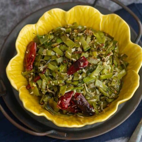 square image of snow peas poriyal served in yellow bowl