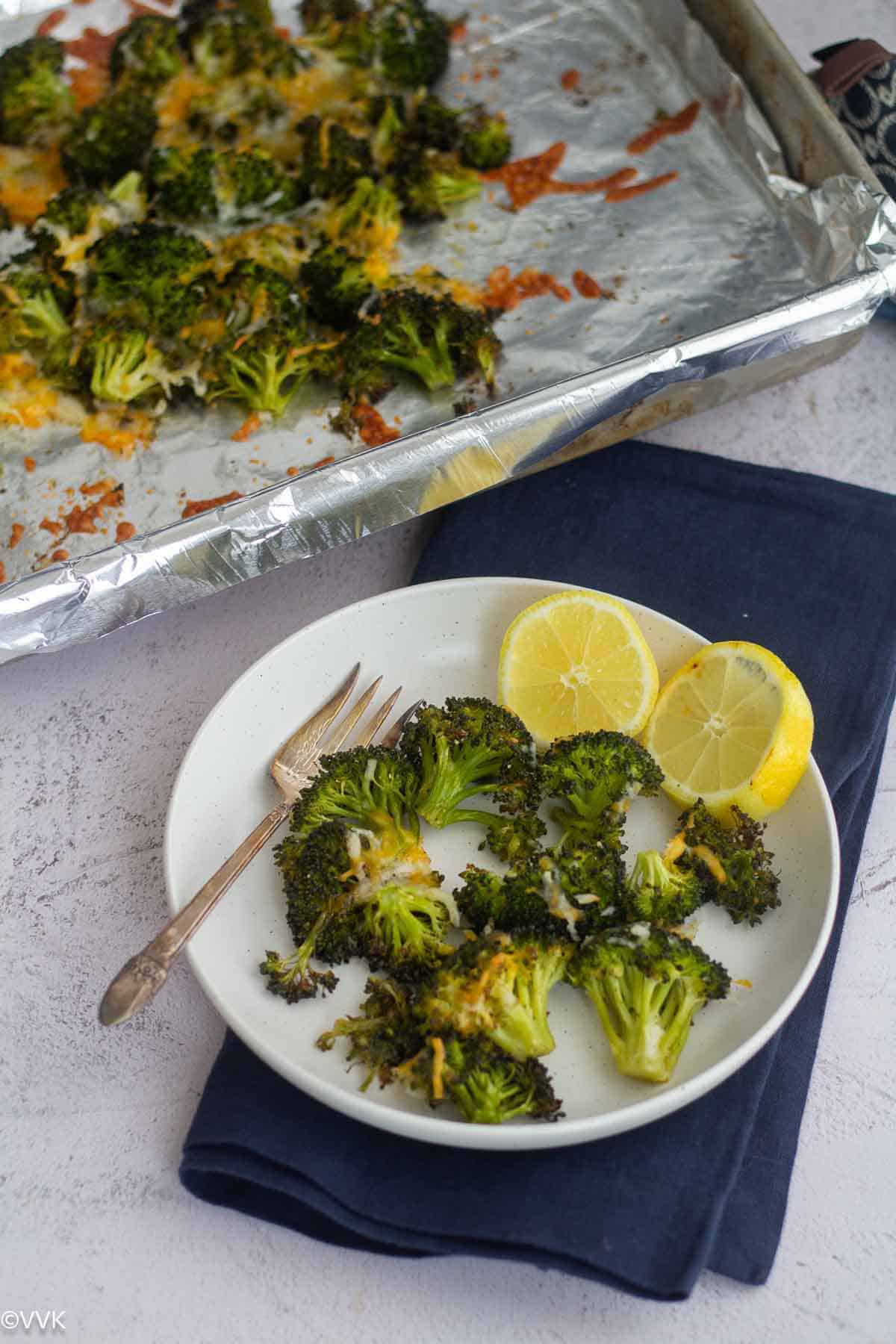 overhead shot of oven roasted broccoli with lemon slices and fork