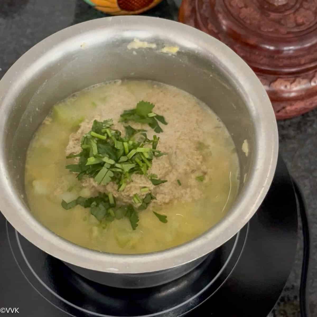simmering the kootu with the spice paste