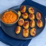 square image of baked tater tots with marinara sauce