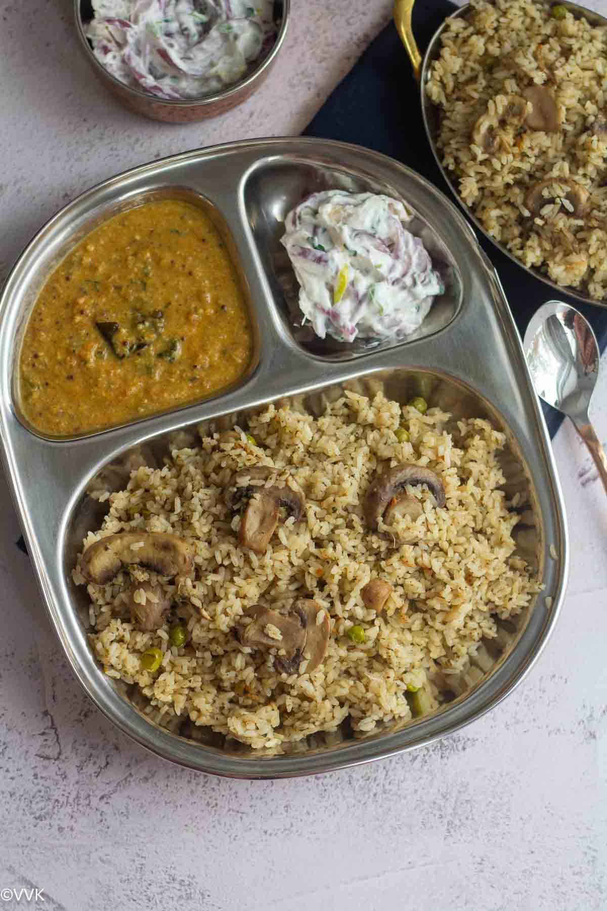 veg thalappakatti biryani served in a plate with raita and salna