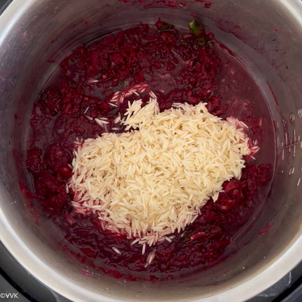 adding rice and water with garam masala