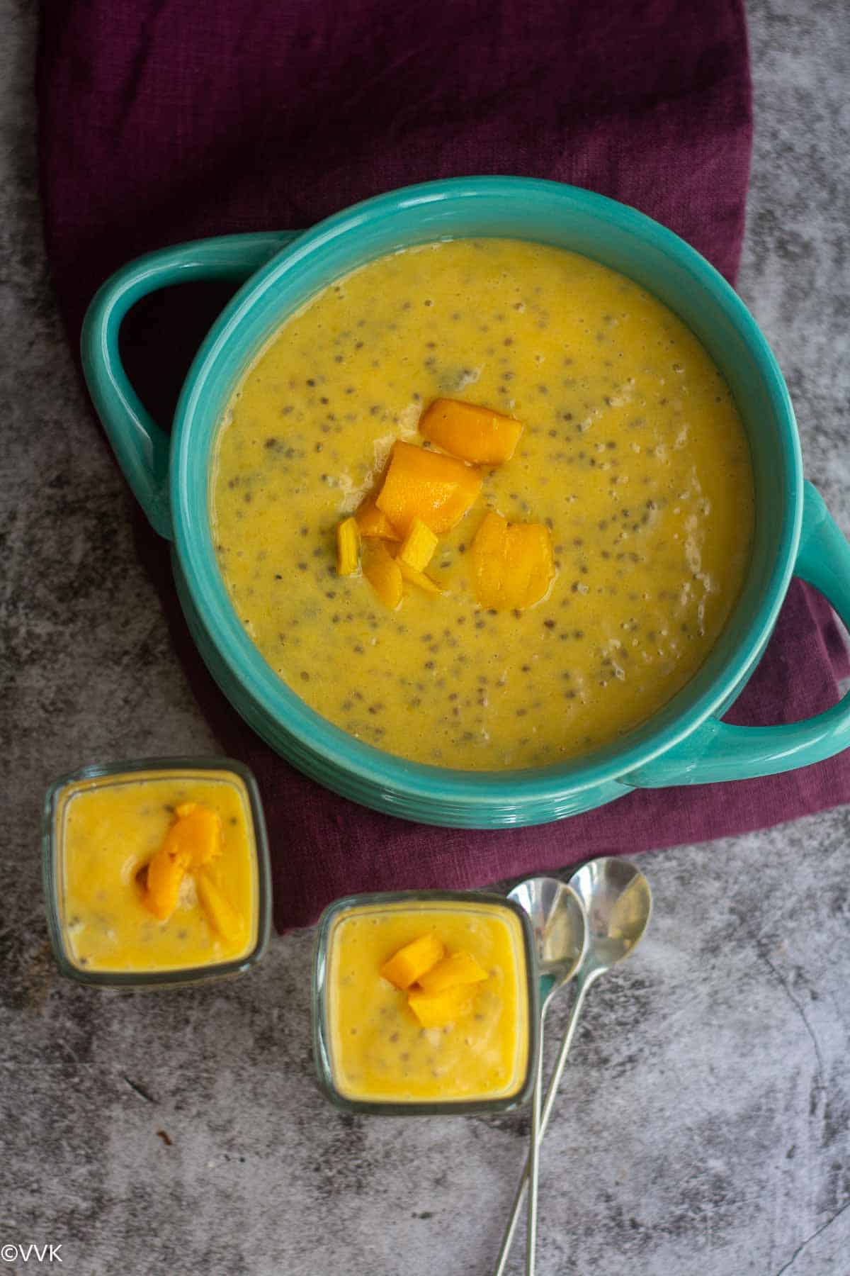 overhead shot mango chia pudding in a teal vessel and two single serve vessel
