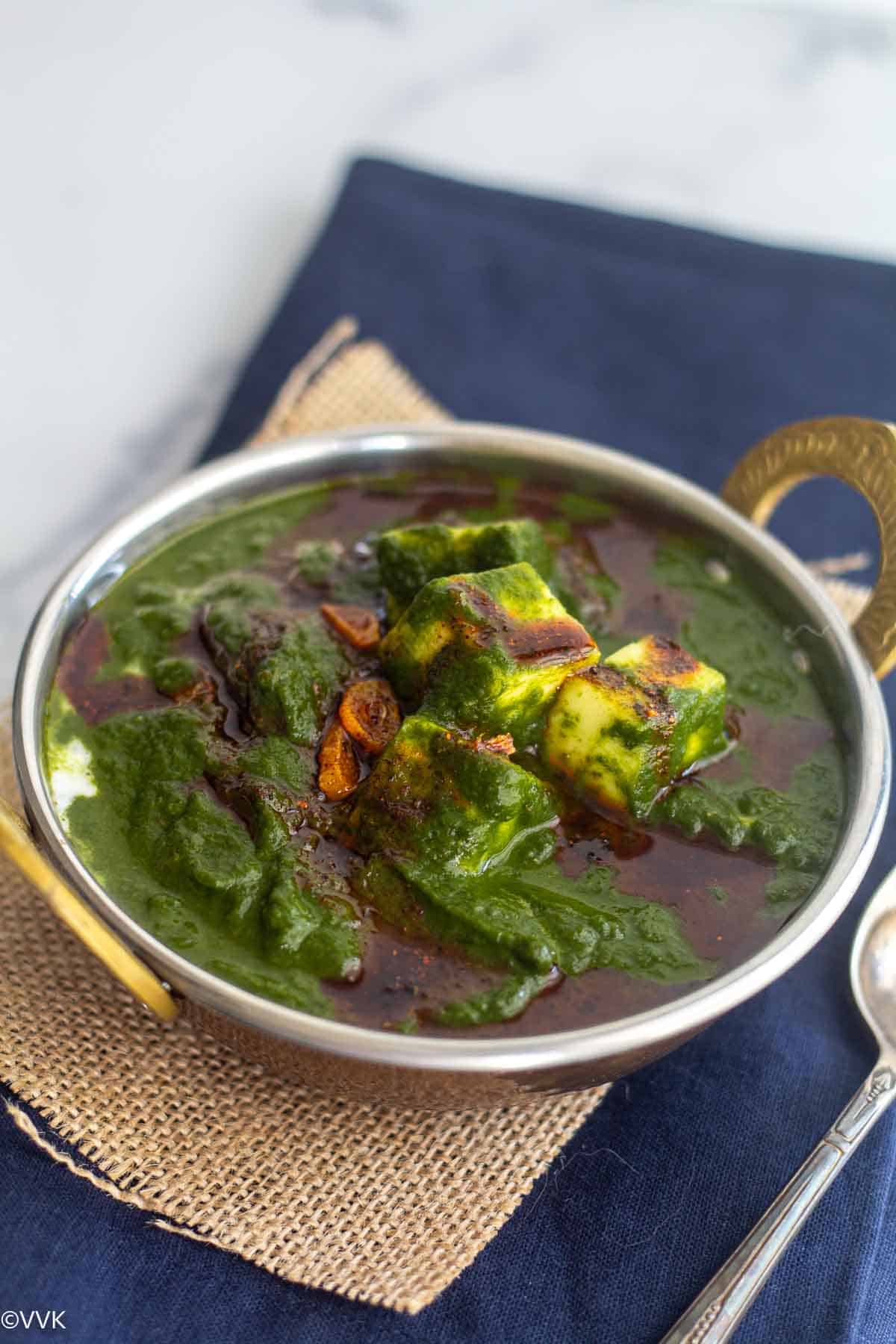 close up shot of palak paneer curry placed on two fabrics