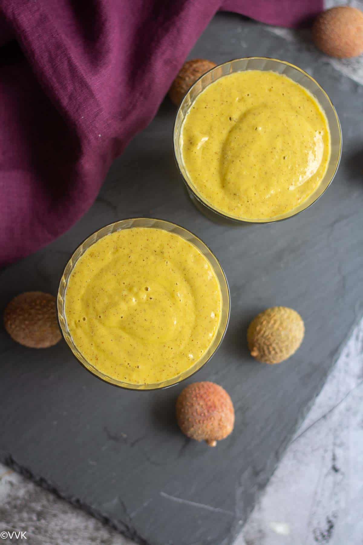 overhead shot of mango pineapple lychee smoothie served in two glasses