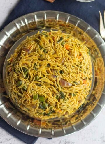 square image of semiya pulao placed on steel plate with a fork on the side