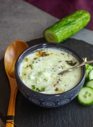 square image of cucumber raita served in a blue bowl