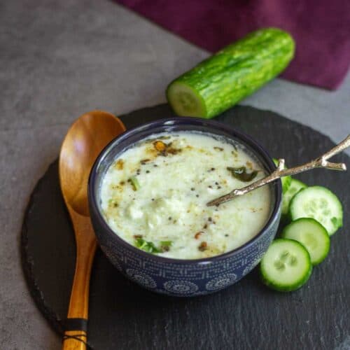 square image of cucumber raita served in a blue bowl