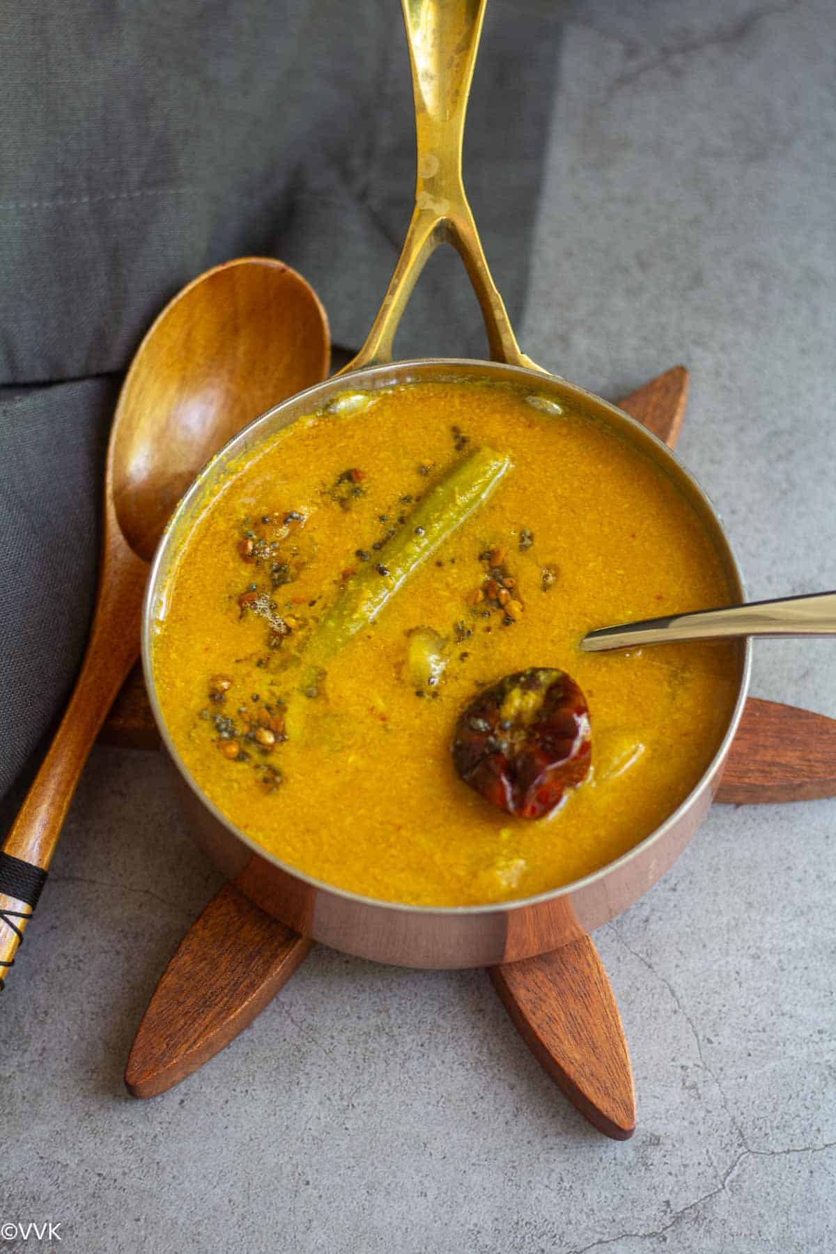 murungakkai sambar with tempering on top served in a copperware