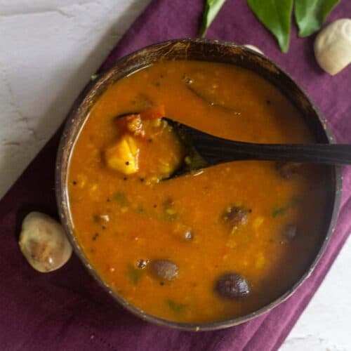 square image of palakottai sambar served in coconut bowl