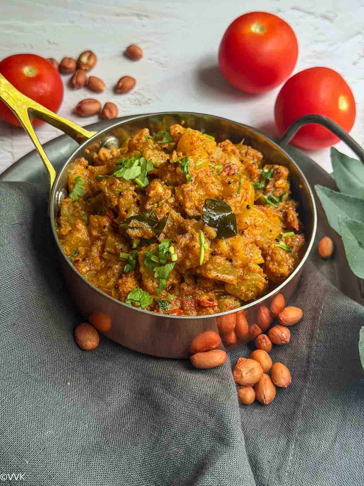 easy bottle gourd peanut curry with peanuts on the side placed on gray towel